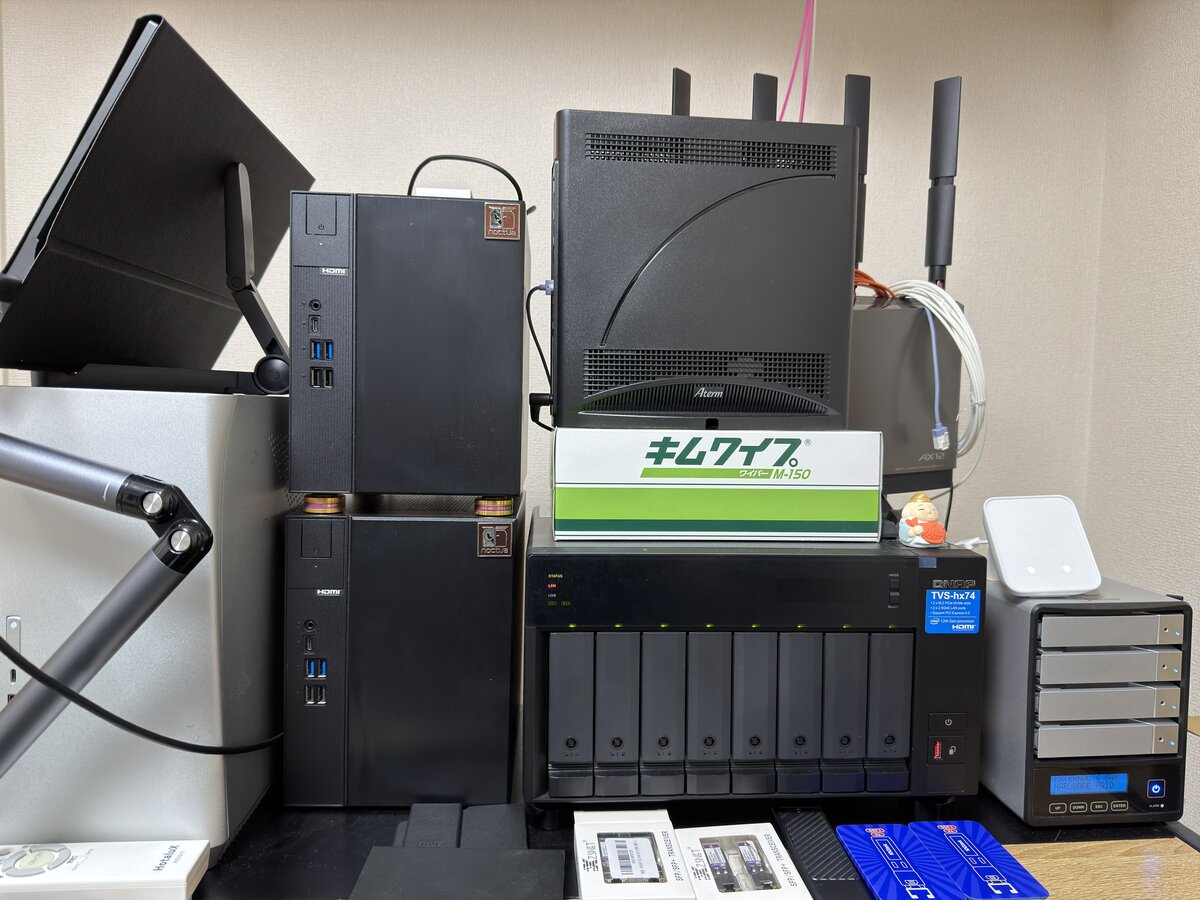 自宅ラボの設置全景。ミニタワー2台の上にWi-Fiルーター、右にQNAP 8ベイNASと外付け4ベイRAIDケース